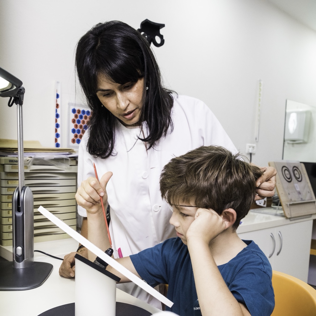 Optometrista realizando una prueba de terapia visual a un niño en la consulta de Visual Center Madhu